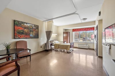 An interior view of a resident room with a bed and seating area