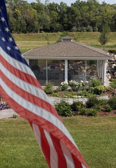 Outdoor gazebo surrounded by landscaped garden and American flag