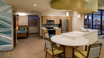 A well-lit kitchen and living space in a senior apartment