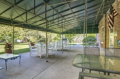 Outdoor seating area with tables and chairs under canopy
