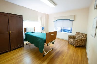 Private resident room with a hospital bed and chair