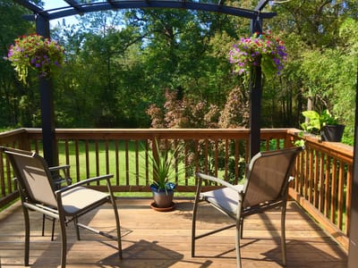 Seating area on a deck surrounded by greenery