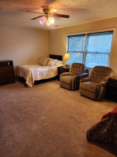 Cozy furnished bedroom with two chairs and a bed