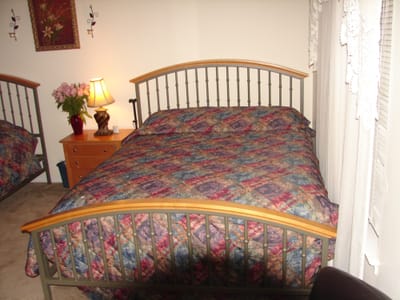Cozy assisted living room with a bed and lamp.