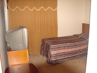 Simple bedroom setup with a bed and TV
