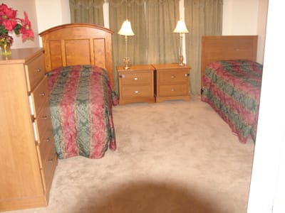 Cozy shared bedroom with two beds and furniture.