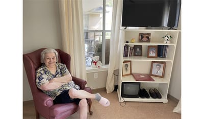 Resident sitting in a chair in their room