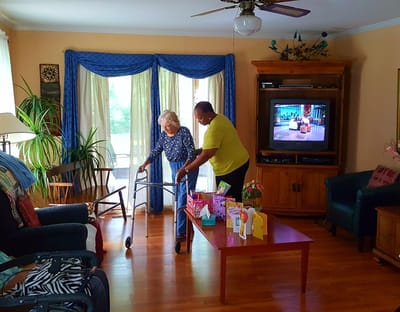Staff assisting a resident in the living room