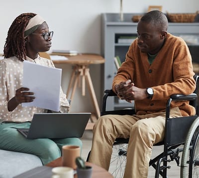 A caregiver discussing with a resident in a living space.