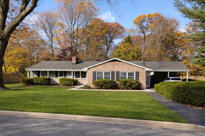 Front exterior of a senior care facility with autumn trees