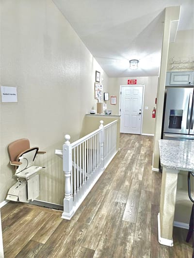 Interior hallway with a stairlift and exit sign