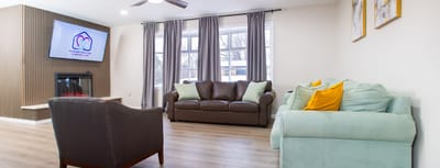 Excellent Home Care & Assisted Living, assisted living in Ellicott City, MD — Cozy living area with comfortable seating and a television