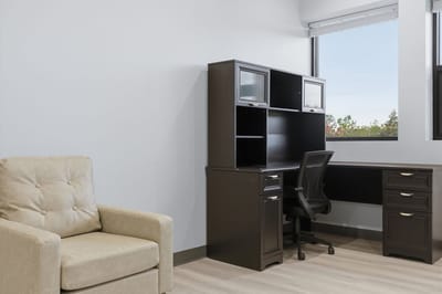 Interior of a private resident room with a desk and chair