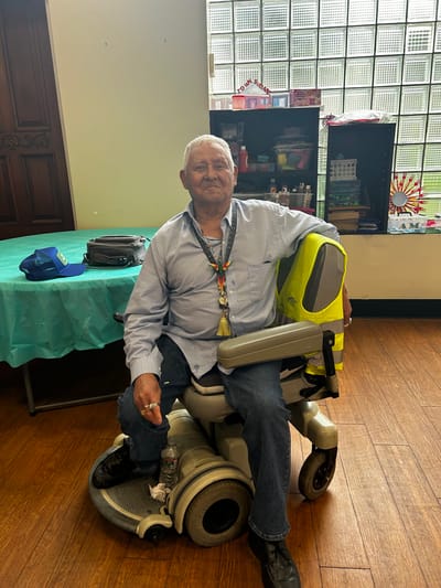 Resident seated in a mobility chair in an indoor activity area