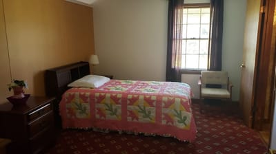 Brightly decorated private resident room with quilt