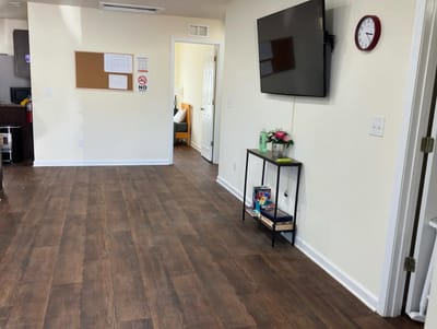 Interior view of a common area with a TV and floral display.