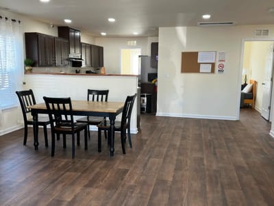 Spacious common area with dining table and kitchen.
