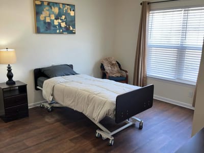 A private resident room with a bed and seating area.