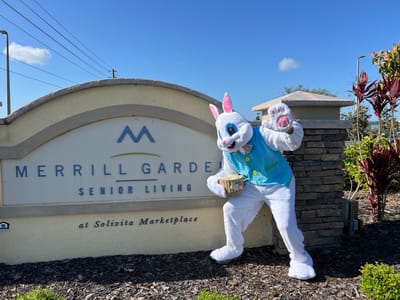 Person in a bunny costume at facility sign.
