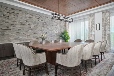 A beautifully designed common area with a table and chairs.