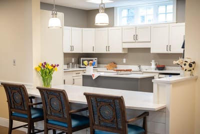 Bright kitchen area with seating and flowers