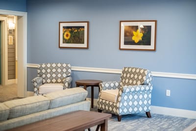 Cozy lounge area with patterned chairs and art.