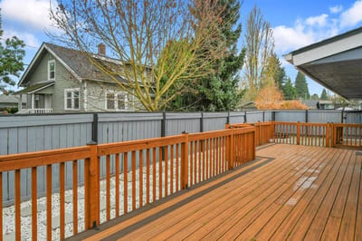 Wooden deck area with trees and houses in background