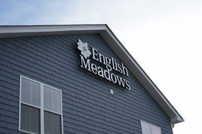 Signage of English Meadows facility on exterior wall.