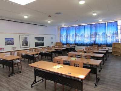 Magnolia Adult Day Care, assisted living in Fort Lee, NJ — Classroom setup with tables and cityscape curtains