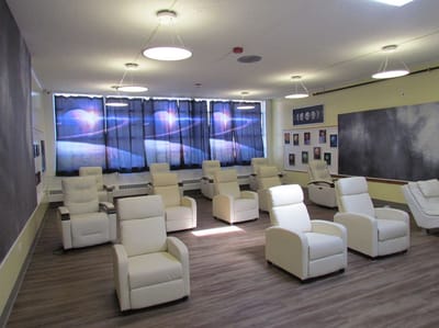 Magnolia Adult Day Care, assisted living in Fort Lee, NJ — Bright activity room with reclining chairs and artwork