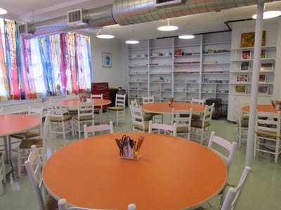 Magnolia Adult Day Care, assisted living in Fort Lee, NJ — Bright activity room with orange tables and colorful curtains