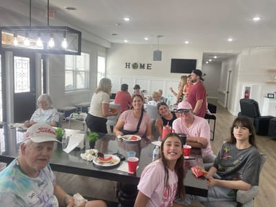 Residents and staff enjoying a meal together in a common area