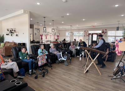 Residents enjoying a musical performance in a cozy common area