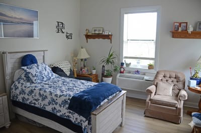 Cozy resident room with bed, chair, and decor