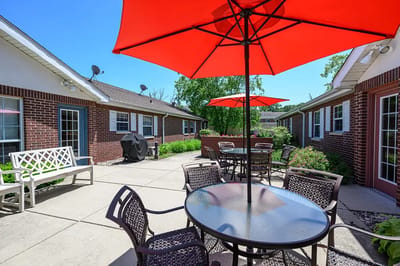 Outdoor patio area with red umbrellas and seating
