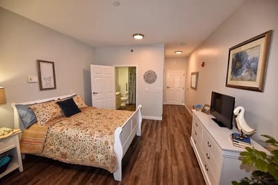 Brightly decorated resident room with a bed and TV