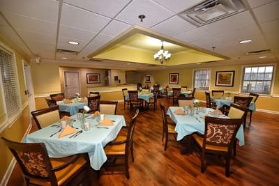 Brightly lit dining room with tables set for meals