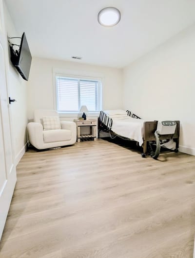 Bright and clean resident room with bed and chair