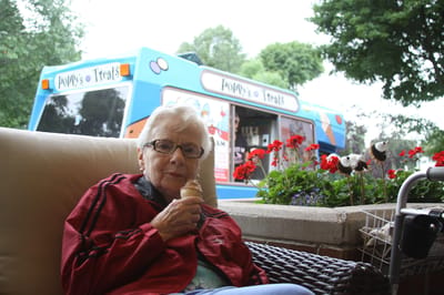 A resident enjoying ice cream outside by flowers