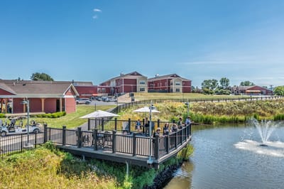 Outdoor deck area with residents enjoying the view by a pond