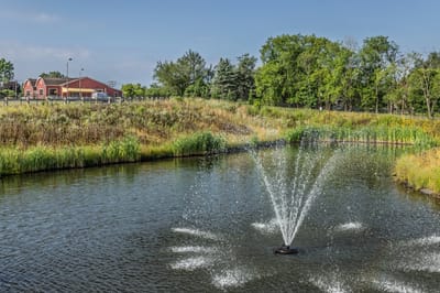 Outdoor view featuring a pond and facility building