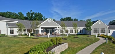 Exterior view of assisted living facility with gardens