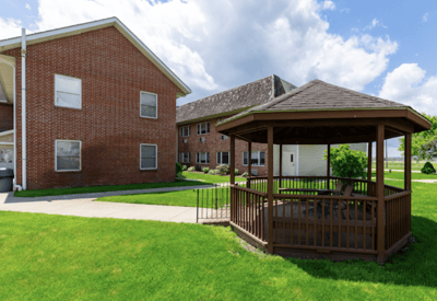 Outdoor gazebo with landscaped green space and building