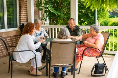 Residents enjoying a card game on the patio