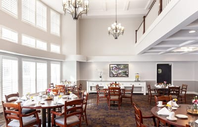 Dining room set for a meal with flowers on tables