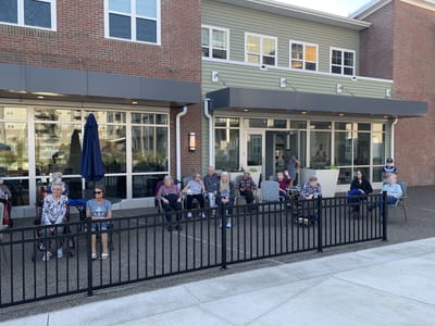 Residents enjoying time outdoors in front of the facility