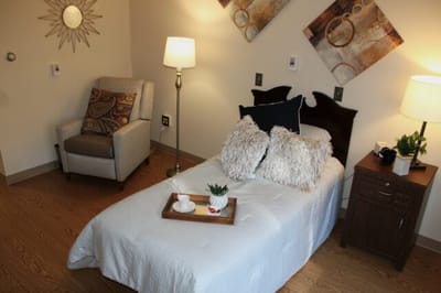 Cozy resident room with a bed and armchair