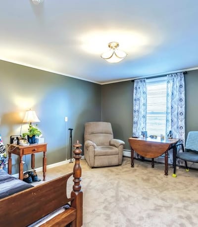 Cozy private resident room with a recliner and window