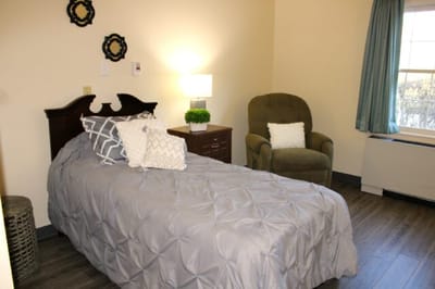 Cozy resident room with bed and chair