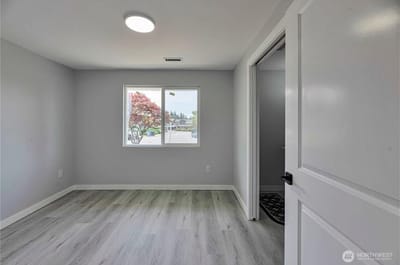 Bright interior room with a window and light wood flooring